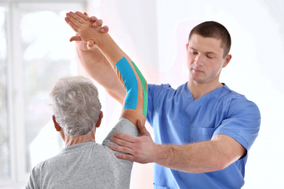 physiotherapist working with elderly patient in clinic