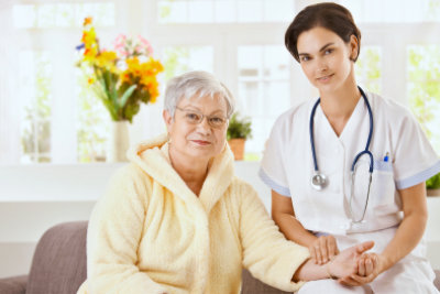 nurse measuring pulse rate of senior woman at home